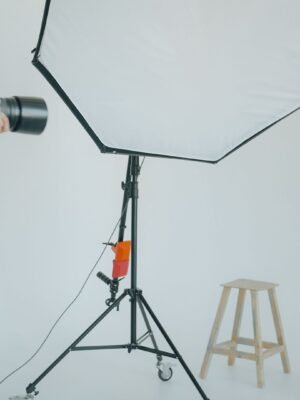 Photographer captures a model in a studio setting with lighting equipment.